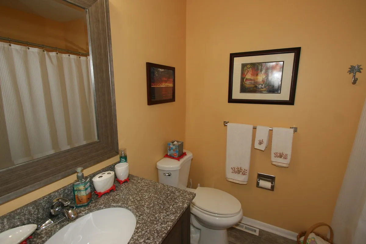 A compact, modern space featuring a granite countertop, framed artwork, clean towels, and a mirror—an organized, inviting area that feels freshly prepared for guests. The neat arrangement suggests attention to cleanliness and detail, aligning with the fresh linens and overall care mentioned.